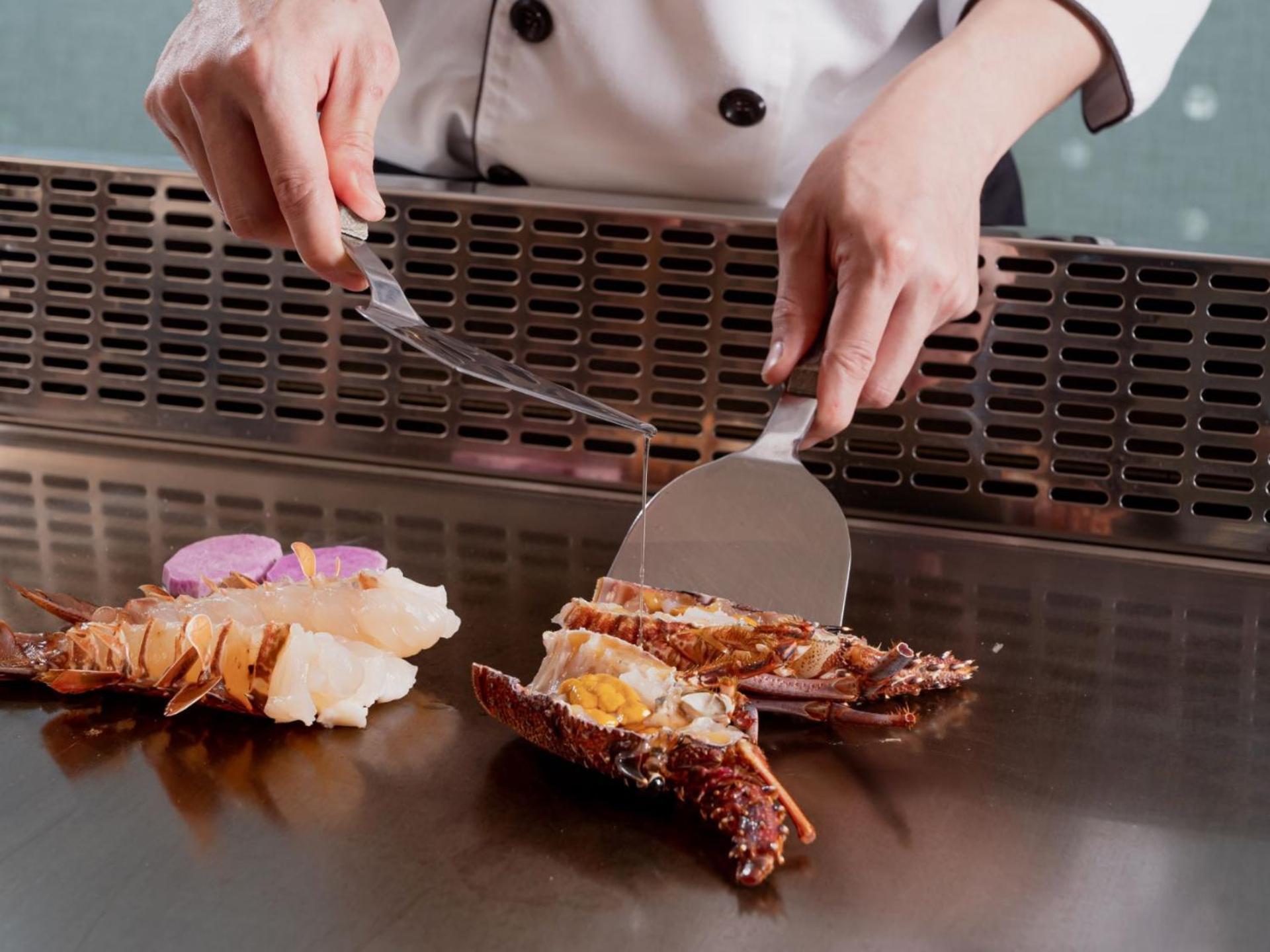 Windsor Hotel Taichung Esterno foto A chef using a fish knife to fillet a lobster